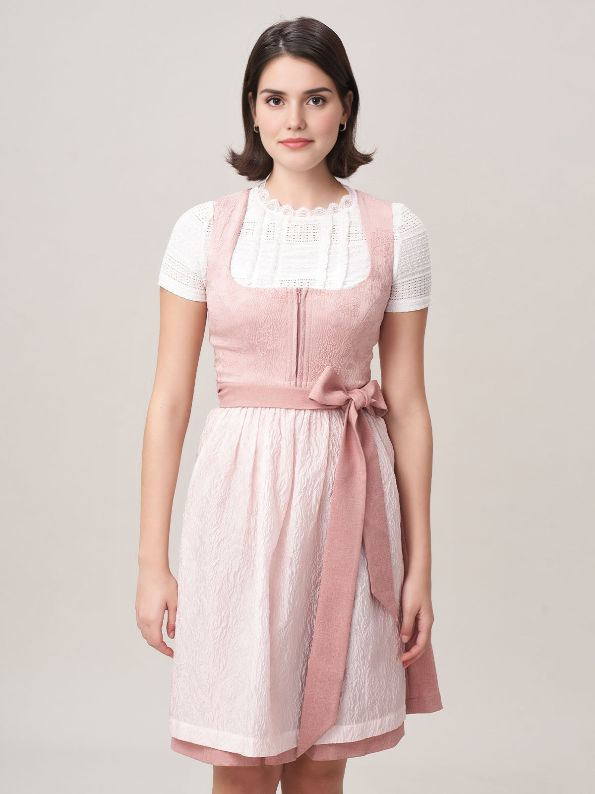 Ein modernes rosa Dirndl mit aufwendiger Stickarbeit und passender Bluse